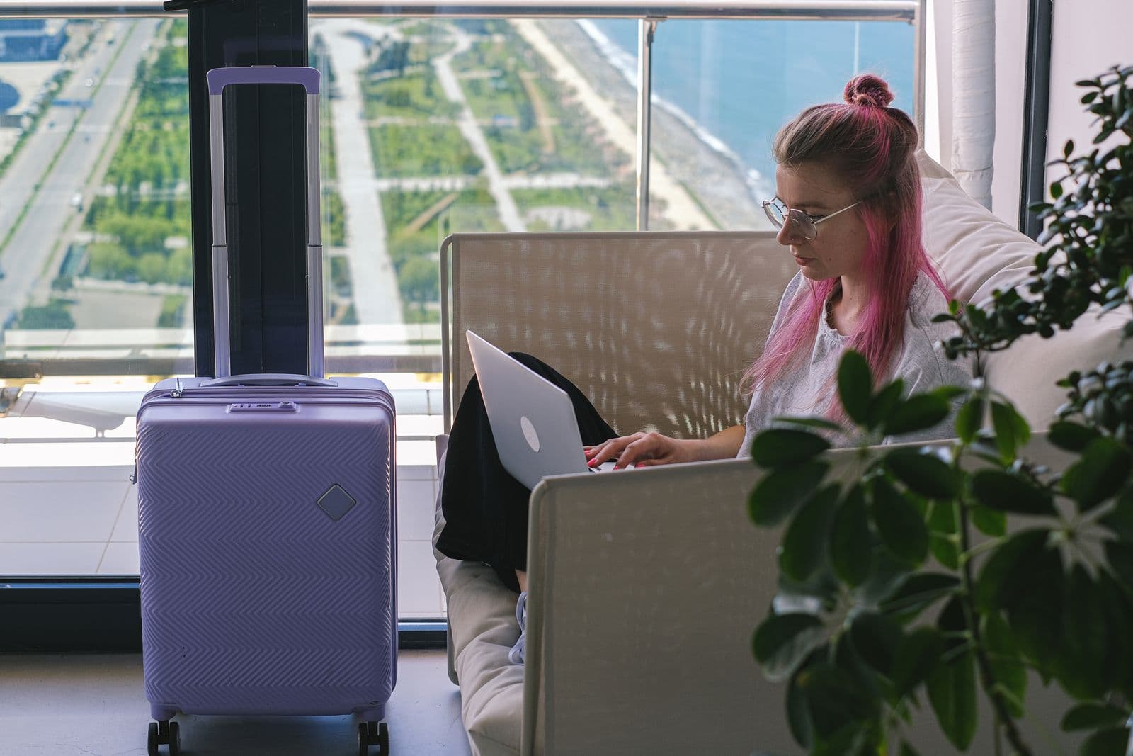 A woman with her suitcase in a hotel room high above the city