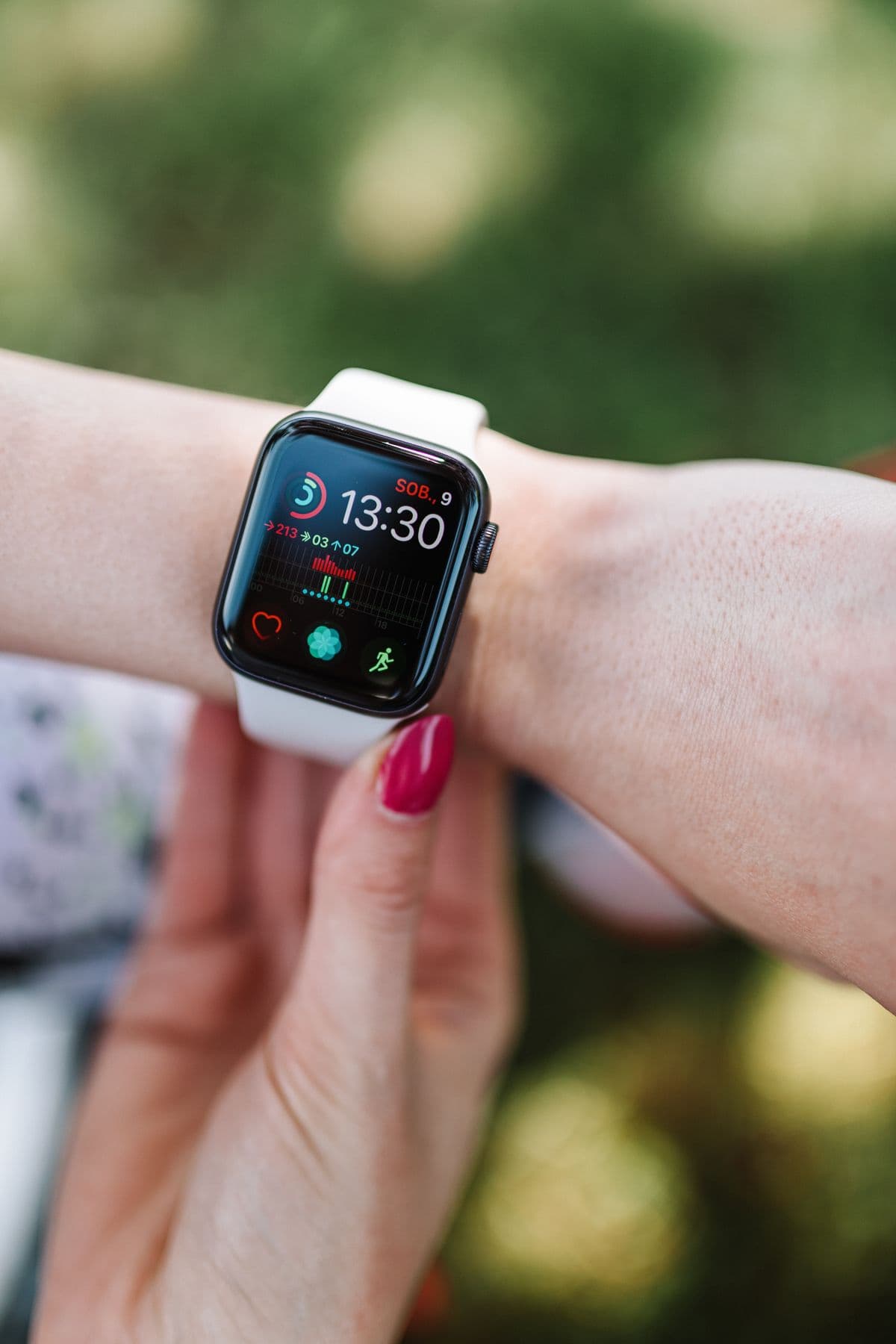 A smartwatch on a woman's wrist showing workout activity and heart rate